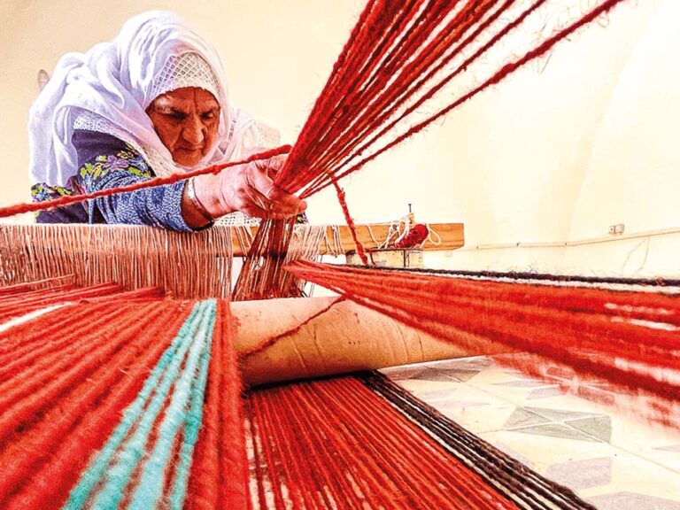 Palestinian woman weaving on a traditional loom